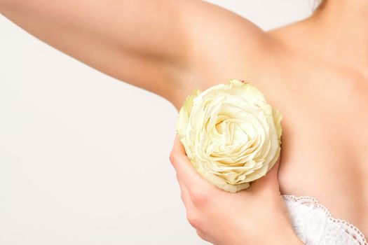 Close up of female armpit with white rose flower isolated on white background