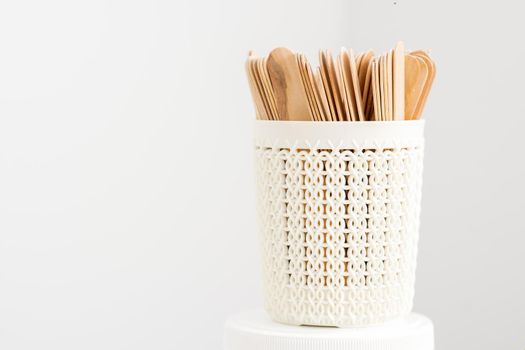 Sticks of wood for wax in white basket isolated on white background with copy space