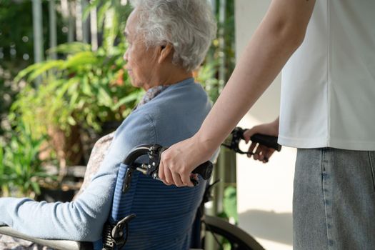 Caregiver help and care Asian senior or elderly old lady woman patient sitting on wheelchair to ramp in nursing hospital, healthy strong medical concept.