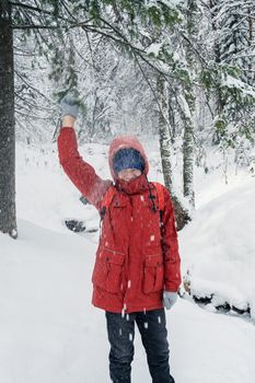 Portrait of teenage boy walking and having fun in winter snowing forest