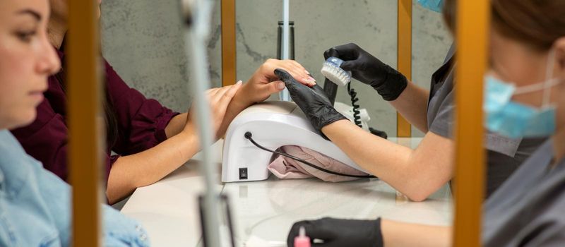 Two women getting a manicure treatment in beauty salon