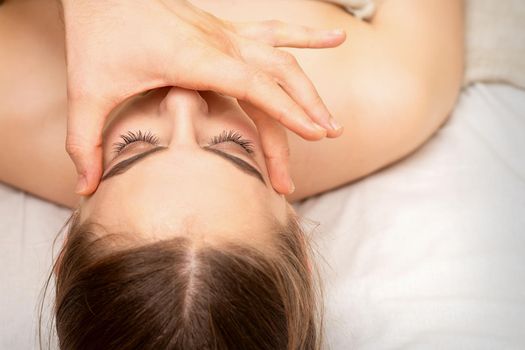Face massage with fingers of a masseur. Female facial skin care at a beauty spa salon