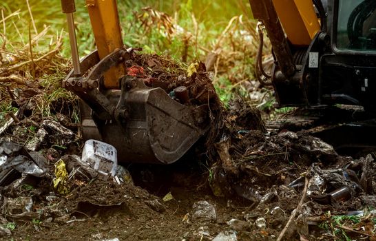 Backhoe digging soil at construction site. Bucket of backhoe digging soil. Clearing and grubbing. Digger working at road construction site. Earth moving machine. Excavation vehicle. Land development.