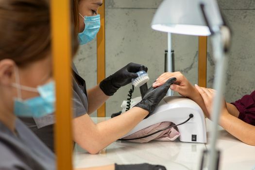 Two women getting a manicure treatment in beauty salon