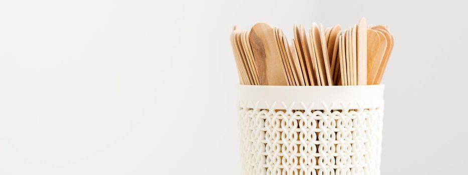 Sticks of wood for wax in white basket isolated on white background with copy space