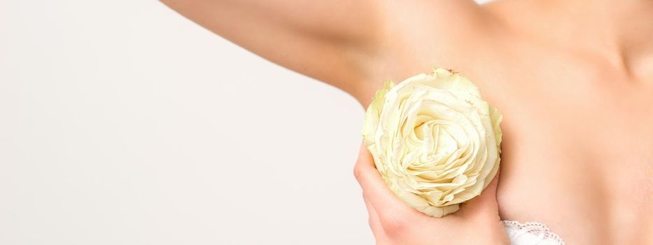 Close up of female armpit with white rose flower isolated on white background