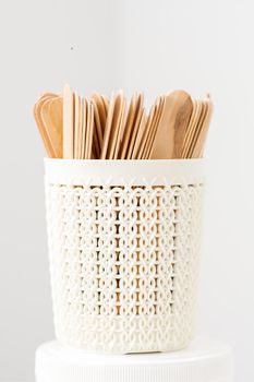 Sticks of wood for wax in white basket isolated on white background with copy space