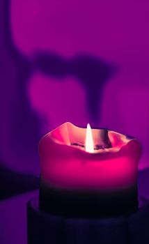 Happy holidays, greeting card backdrop and winter season concept - Pink holiday candle on purple background, luxury branding design and decoration for Christmas, New Years Eve and Valentines Day