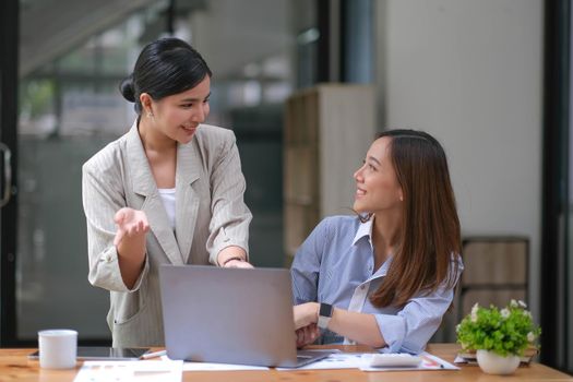 Two Young Asian businesswoman discuss with new startup project Idea presentation, analyze planning and financial statistics and investment market at office..