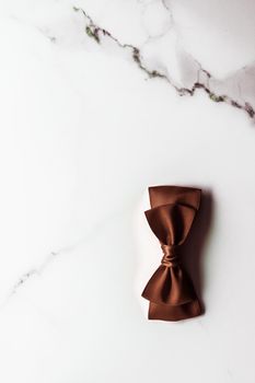 Holiday gift, decoration and sale promotion concept - Chocolate brown silk ribbon on marble background, flatlay