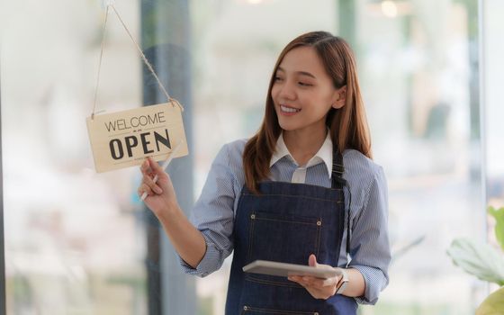 Asian Barista cafe owner smile while cafe open. SME entrepreneur seller business concept.