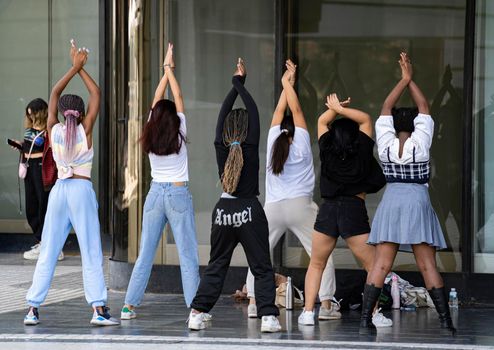 Group of multiethnic young girls dancing hip hop on the street. Crew making show in an urban place.