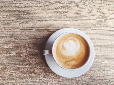 Morning drink, breakfast and rustic style concept - Cup of hot cappuccino in a cafeteria, coffee on a wooden table in cafe