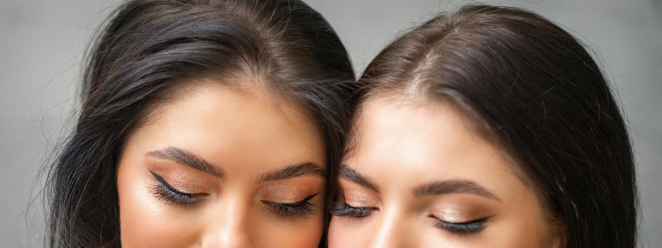 Portrait of young beautiful two women with long lashes and closed eyes after eyelash extensions