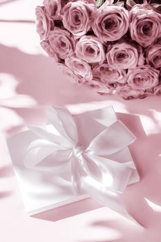 Happy holidays, luxe shopping and love gifts concept - Luxury holiday silk gift box and bouquet of roses on blush pink background, romantic surprise and flowers as birthday or Valentines Day present