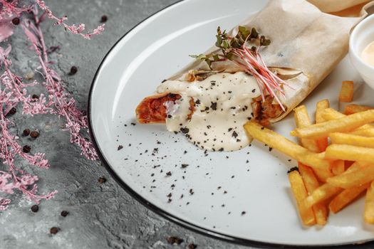 Shawarma Sandwich with French Fires and Salt Grinder on Dark Background.