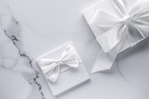 Romantic celebration, bridal decor and holiday present concept - Luxury wedding gifts with silk bow and ribbons on marble background