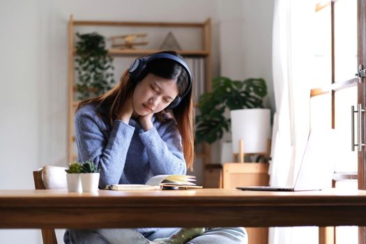 Beautiful Asian women get tired after studying online for a long time, she is studying online. The concept of online learning due to the COVID-19 outbreak to prevent an outbreak in the classroom..