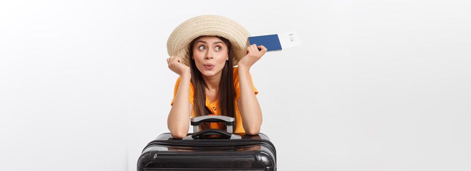 Travel concept. Studio portrait of pretty young woman holding passport and luggage. Isolated on white.