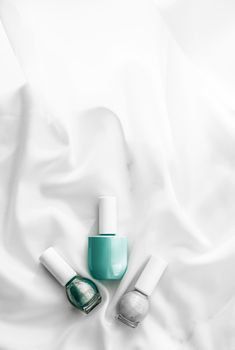 Cosmetic branding, salon and glamour concept - Nail polish bottles on silk background, french manicure products and nailpolish make-up cosmetics for luxury beauty brand and holiday flatlay art design