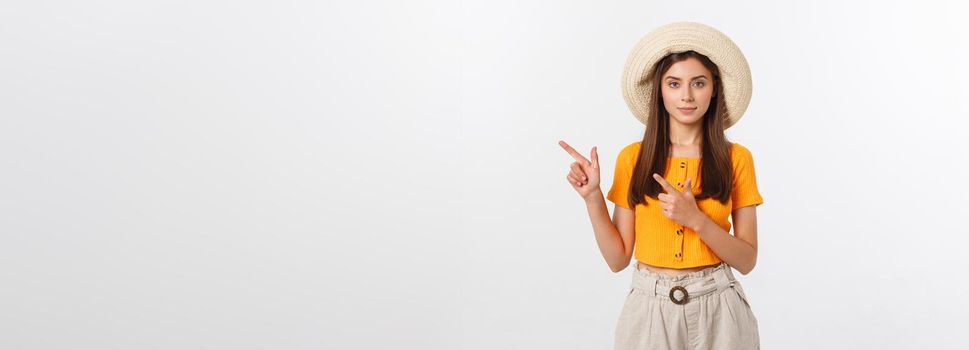 Teenager girl on summer vacation surprised and pointing finger on copy space over isolated white background