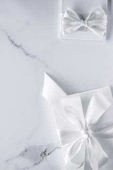 Romantic celebration, bridal decor and holiday present concept - Luxury wedding gifts with silk bow and ribbons on marble background