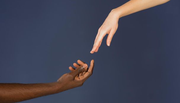 Interracial communication and cooperation of human being. Black and white male and female hands isolated on blue background. BLM concept. All Lives matter concept.