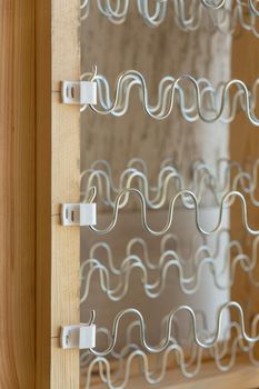 View of spring shock absorbers stretched on a frame inside a modern soft sofa. Modern springs do not creak and retain their properties for a long time.