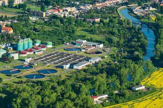 Aerial view of sewage treatment plant in the city near the river and residential area