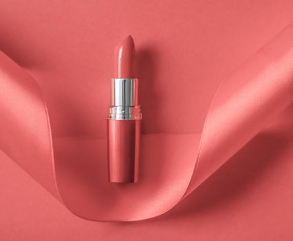 Cosmetic branding, glamour lip gloss and shopping sale concept - Luxury lipstick and silk ribbon on coral holiday background, make-up and cosmetics flatlay for beauty brand product design