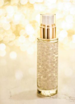 Cosmetic branding, blank label and glamour present concept - Holiday make-up base gel, serum emulsion, lotion bottle and golden glitter, luxury skin and body care cosmetics for beauty brand ads