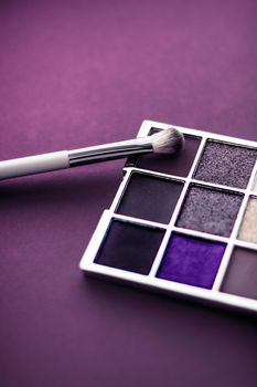 Cosmetic branding, mua and girly concept - Eyeshadow palette and make-up brush on purple background, eye shadows cosmetics product as luxury beauty brand promotion and holiday fashion blog design