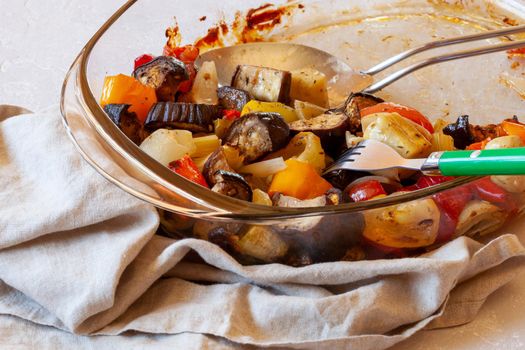 oven dish with baked vegetables, family size, half eaten, side view