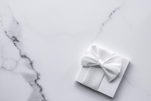 Romantic celebration, bridal decor and holiday present concept - Luxury wedding gifts with silk bow and ribbons on marble background