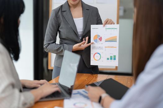 Business asian presenting analytical report while working together with colleagues in the modern office.