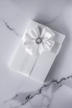 Romantic celebration, bridal decor and holiday present concept - Luxury wedding gifts with silk bow and ribbons on marble background