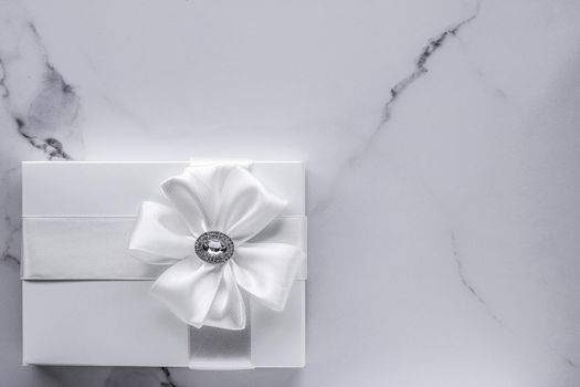 Romantic celebration, bridal decor and holiday present concept - Luxury wedding gifts with silk bow and ribbons on marble background