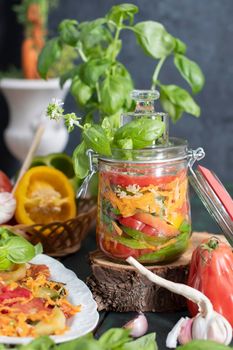 orange salad of paprika,tomatoes, carrots and basil for harvesting for the winter in a jar. High quality photo
