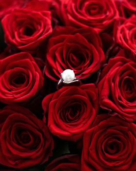 Gemstone jewellery, wedding present and engagement proposal concept - Beautiful white gold pearl ring and bouquet of red roses, luxury jewelry love gift on Valentines Day and romantic holidays