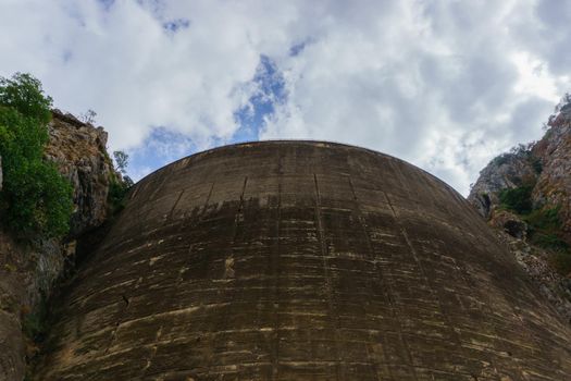 bottom view of a large dam emptied by severe drought and climate change under cloudy skies