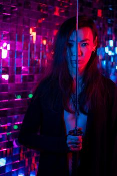 Male transgender neon light studio. Asian with samurai sword