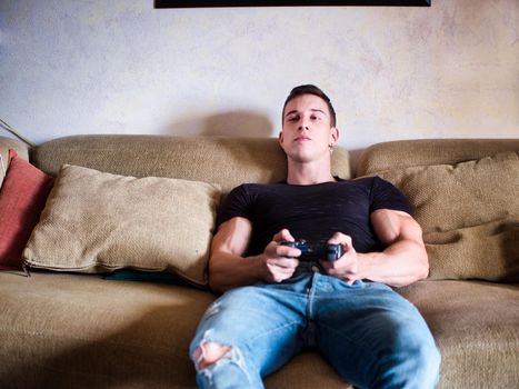 Good looking young man holding joystick, gamepad or joypadplaying video game