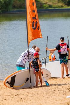 Children stand on the beach with surfboards. Paddleboarding. Russia Zelenograd 14 August 2021