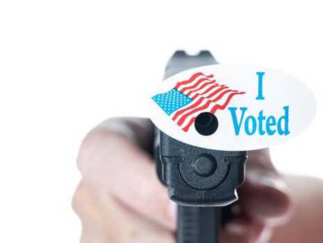 Concept for election violence with handgun decorated with I voted today sticker with hole made by fired bullet