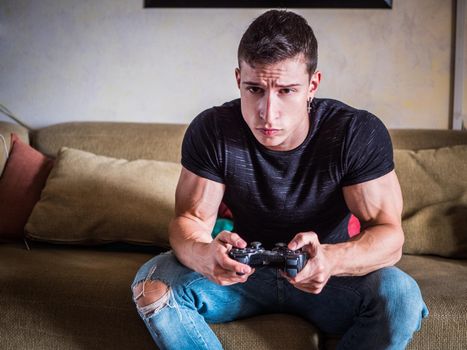 Good looking young man holding joystick, gamepad or joypadplaying video game