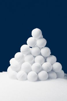 snowballs pyramidal heap on dark blue background