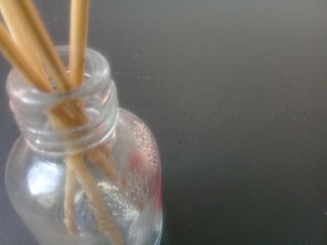 Close-Up Of Incense Sticks In glass Container Against Gray Background. Traditional aroma sticks for fragrance refreshing air