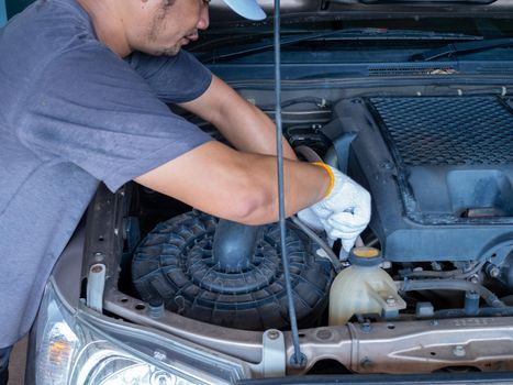 Mechanic holding a block wrench handle while fixing a car.