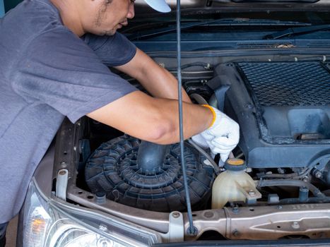 Mechanic holding a block wrench handle while fixing a car.