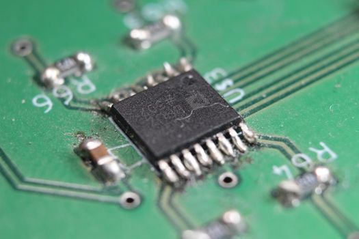 Electronic board with circuit lines and chip. Macro view of green board